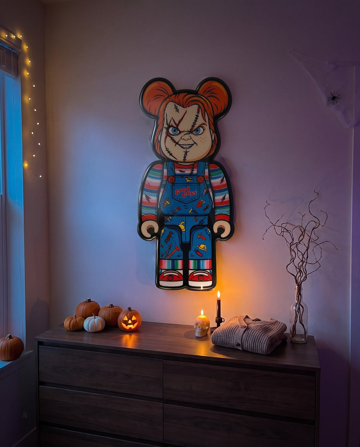 Chucky Halloween Bear Wall Art hanging on the wall above a dresser in a Halloween-decorated room