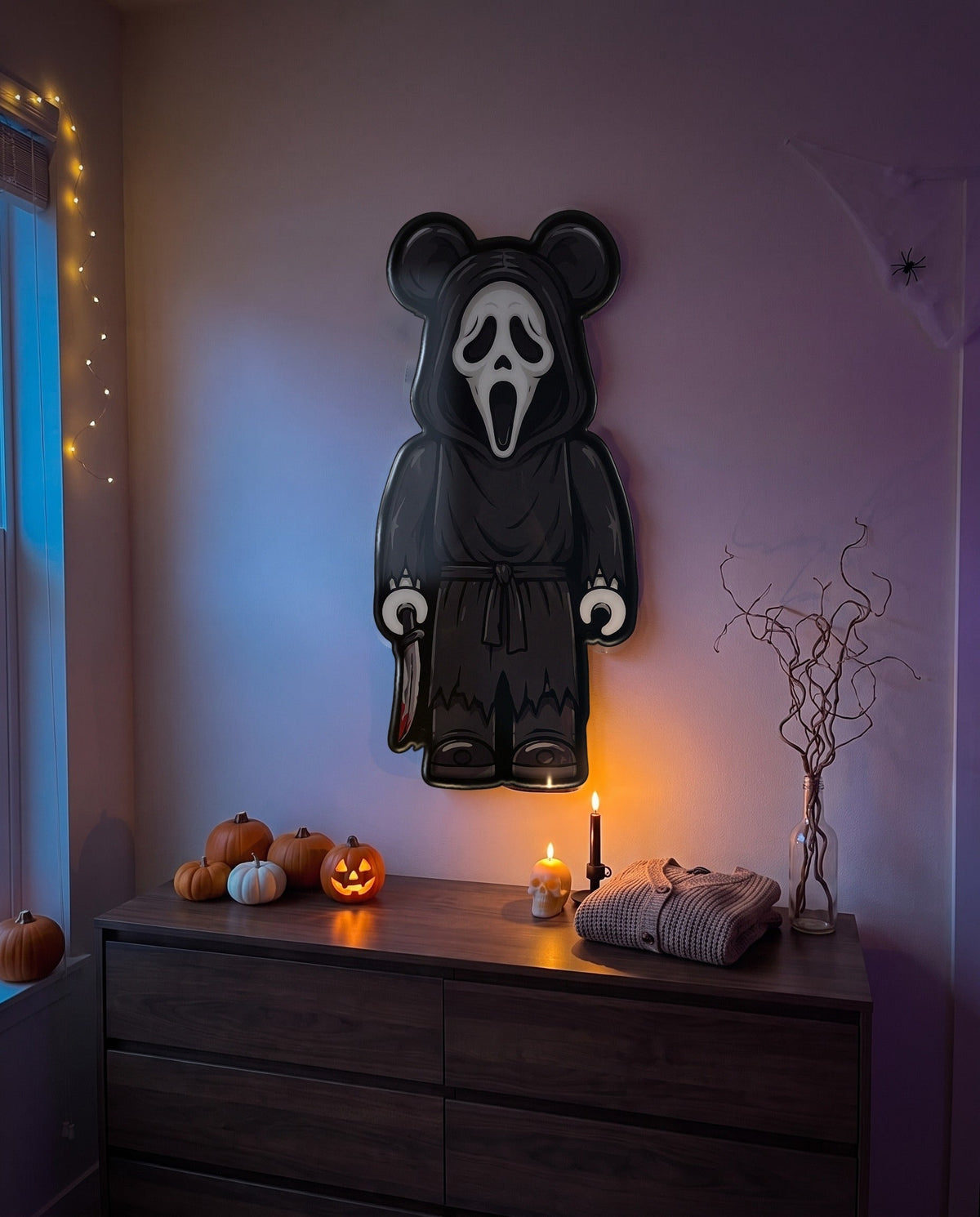 Ghostface Halloween Bear Wall Art hanging on the wall above a dresser in a Halloween-decorated room