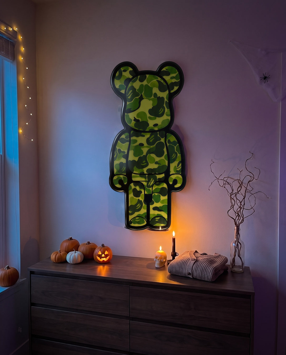 Green Camo Bear Wallart hanging on the wall above a dresser in a Halloween-decorated room
