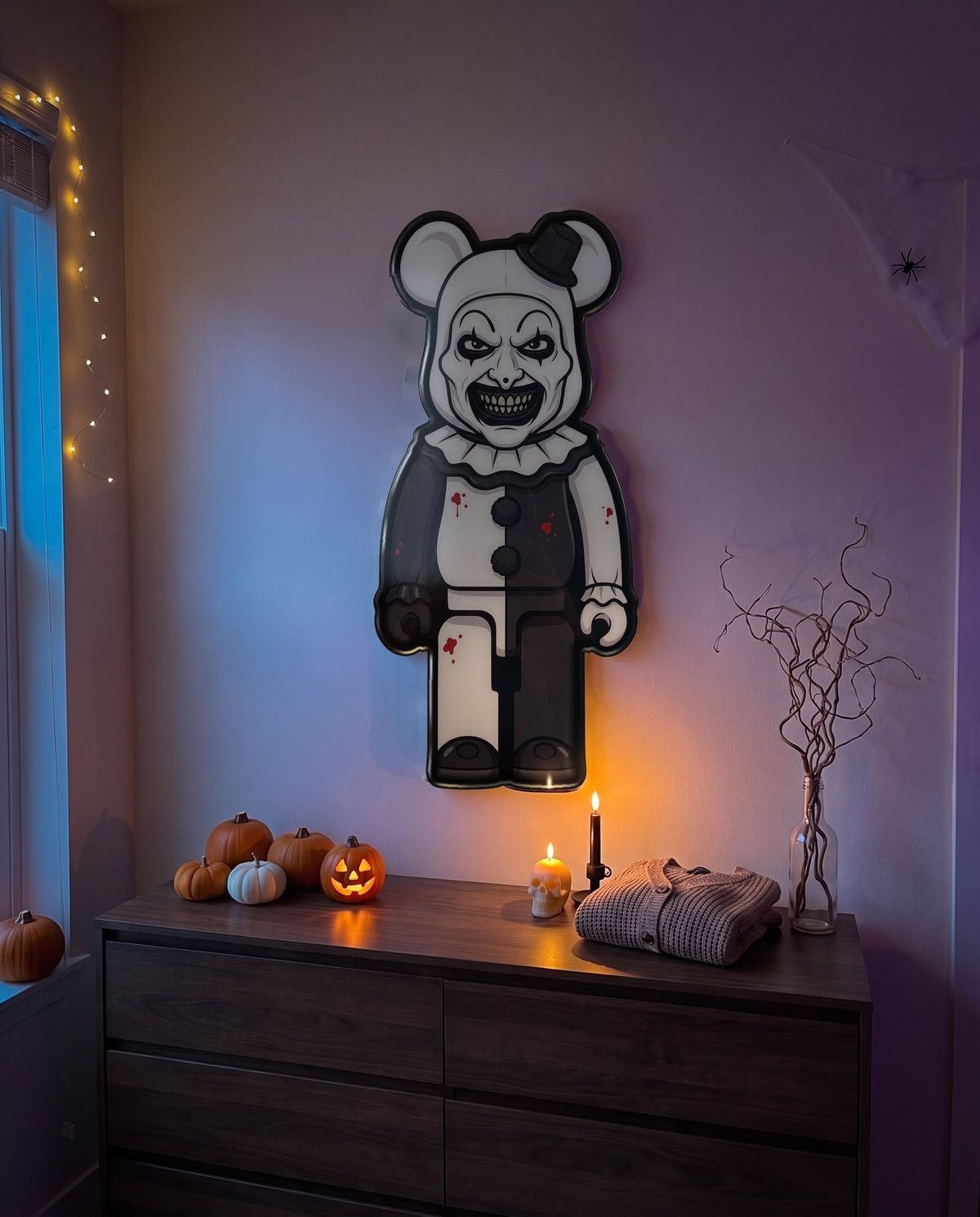 Art the Clown Halloween Bear Wall Art hanging on the wall above a dresser in a Halloween-decorated room