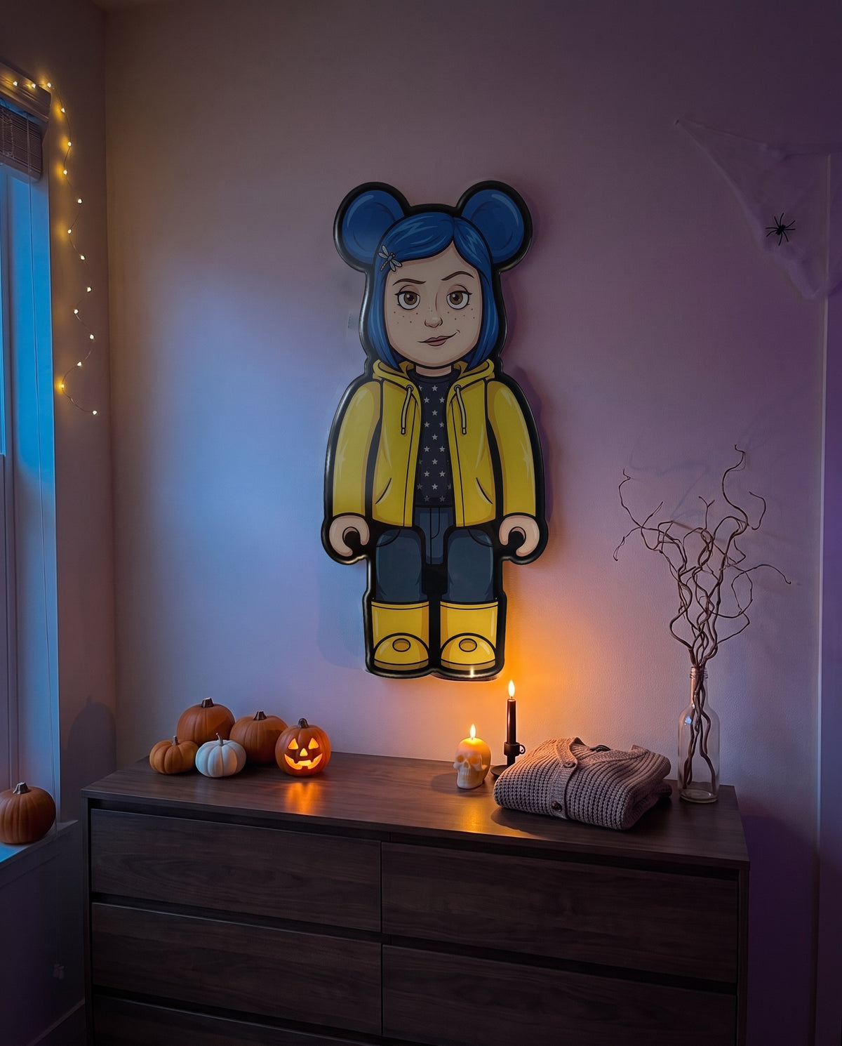 Coraline Halloween Bear Wall Art hanging on the wall above a dresser in a Halloween-decorated room