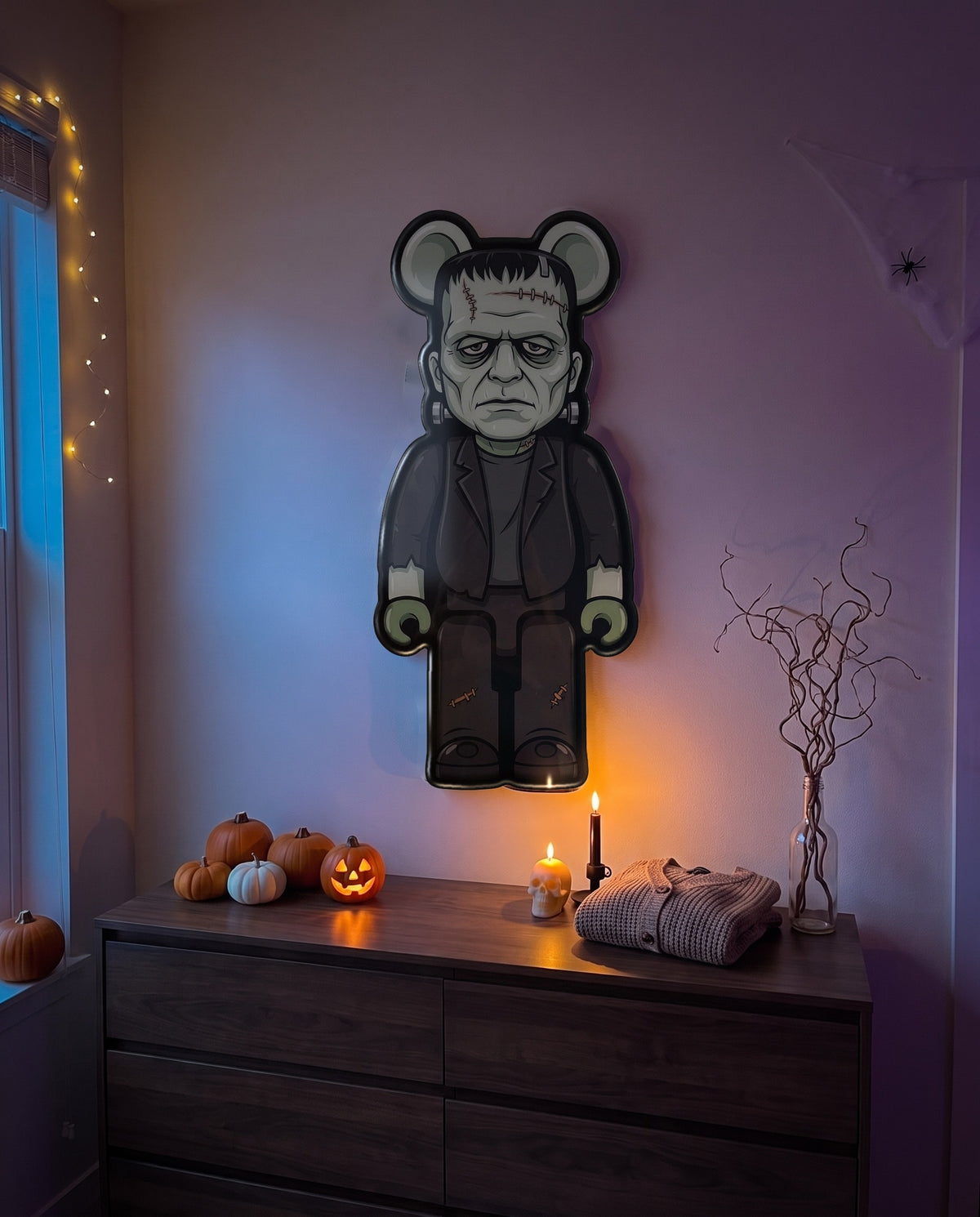 Frankenstein Halloween Bear Wall Art hanging on the wall above a dresser in a Halloween-decorated room