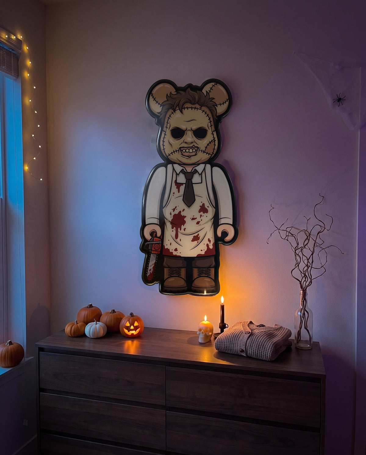 Leatherface Halloween Bear Wall Art hanging on the wall above a dresser in a Halloween-decorated room