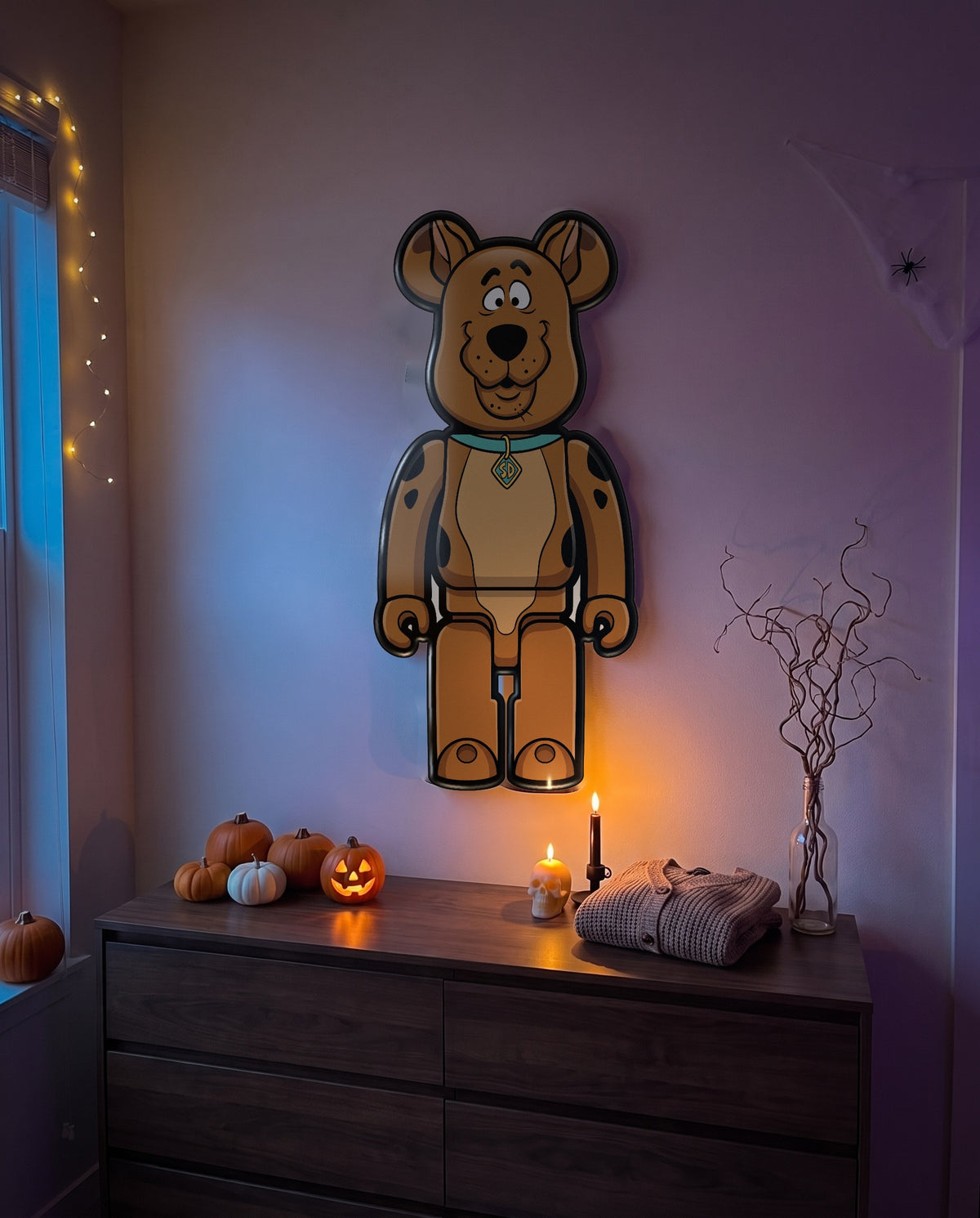 Scooby-Doo Halloween Bear Wall Art hanging on the wall above a dresser in a Halloween-decorated room
