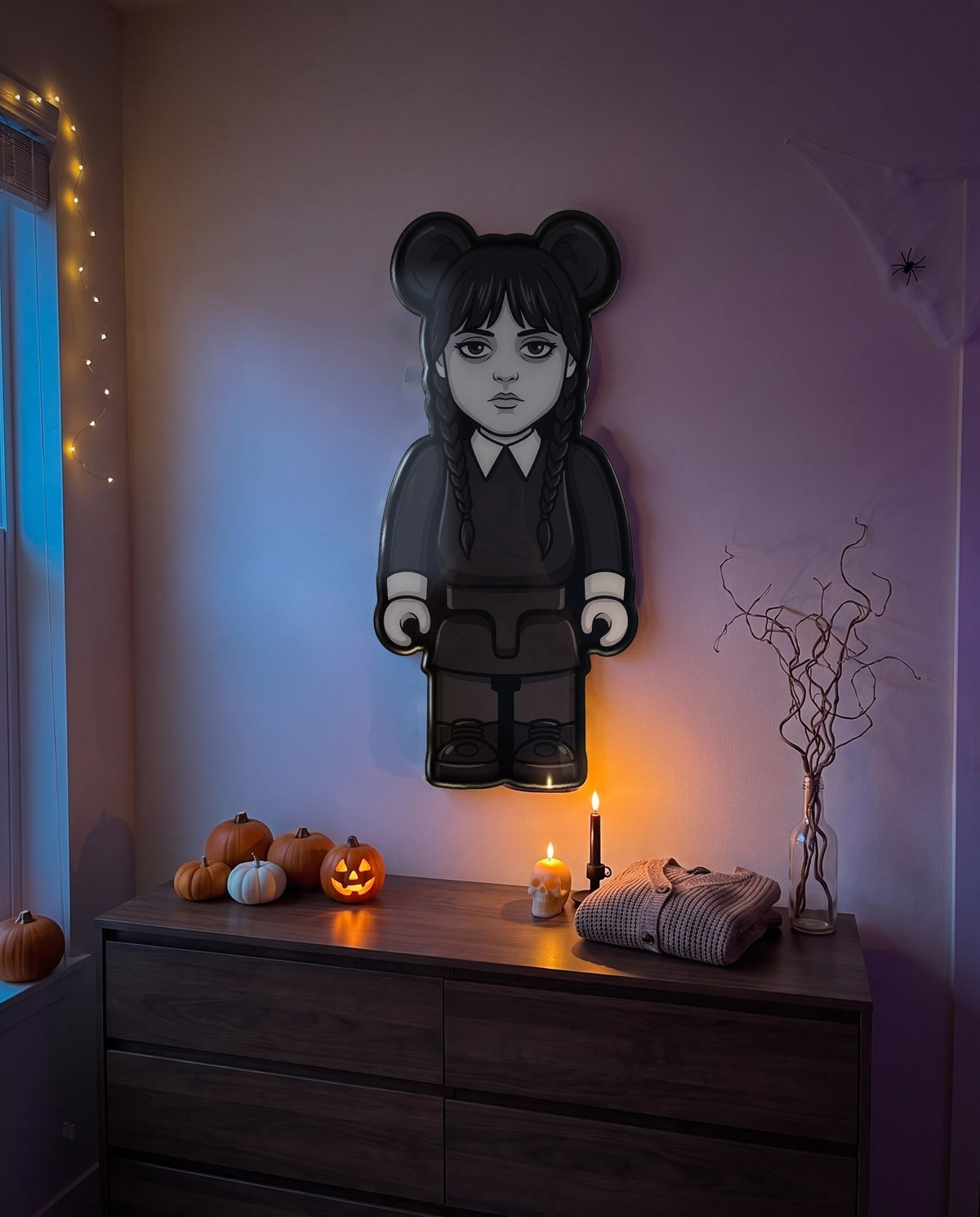 Wednesday Halloween Bear Wall Art hanging on the wall above a dresser in a Halloween-decorated room
