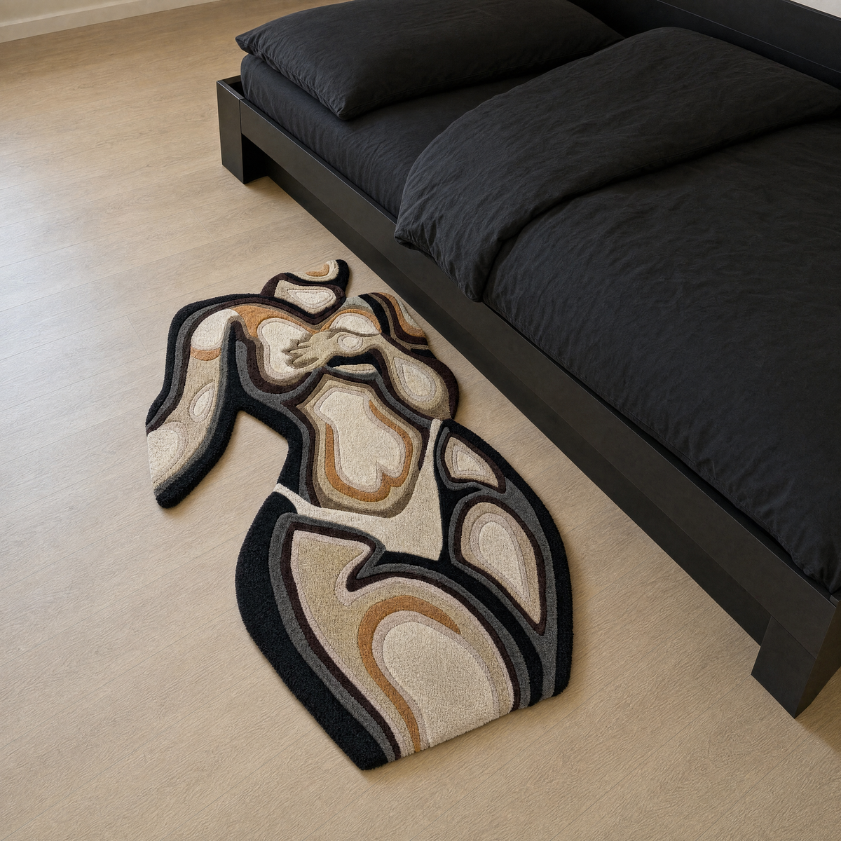 Custom hand-tufted rug on a light wood floor beside a matte black bed in a minimal black bedroom