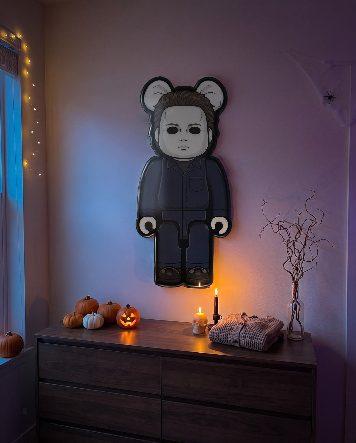 Michael Myers Halloween Bear Wall Art hanging on the wall above a dresser in a Halloween-decorated room