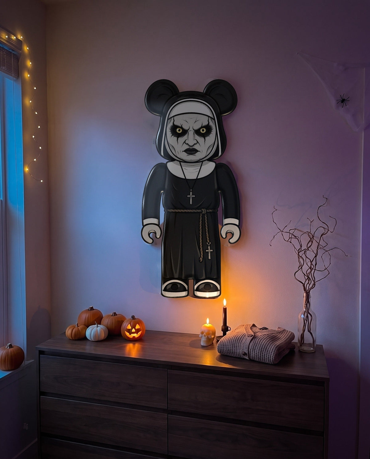 The Nun Halloween Bear Wall Art hanging on the wall above a dresser in a Halloween-decorated room