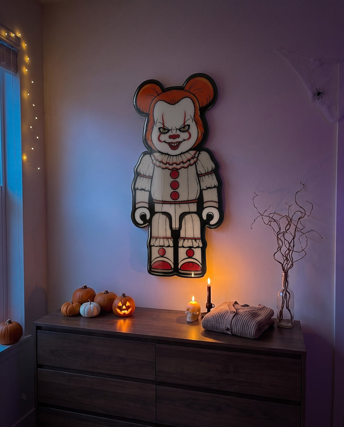 Pennywise Halloween Bear Wall Art hanging on the wall above a dresser in a Halloween-decorated room